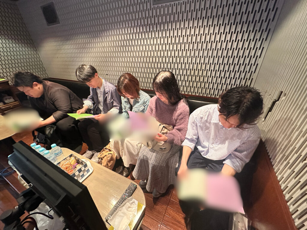 アニメ「こめかみっ！ガールズ」の収録前に、真剣に台本をチェックする声優スクールの生徒たち